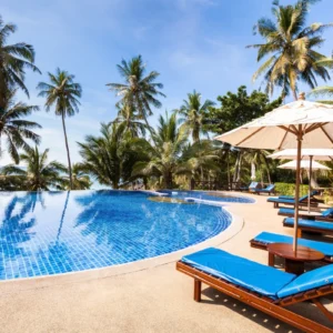 Tropical resort pool with palm trees.