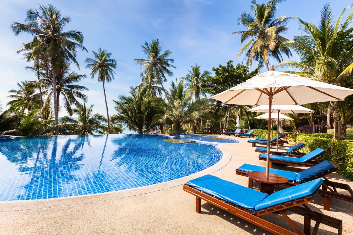 Tropical resort pool with palm trees.